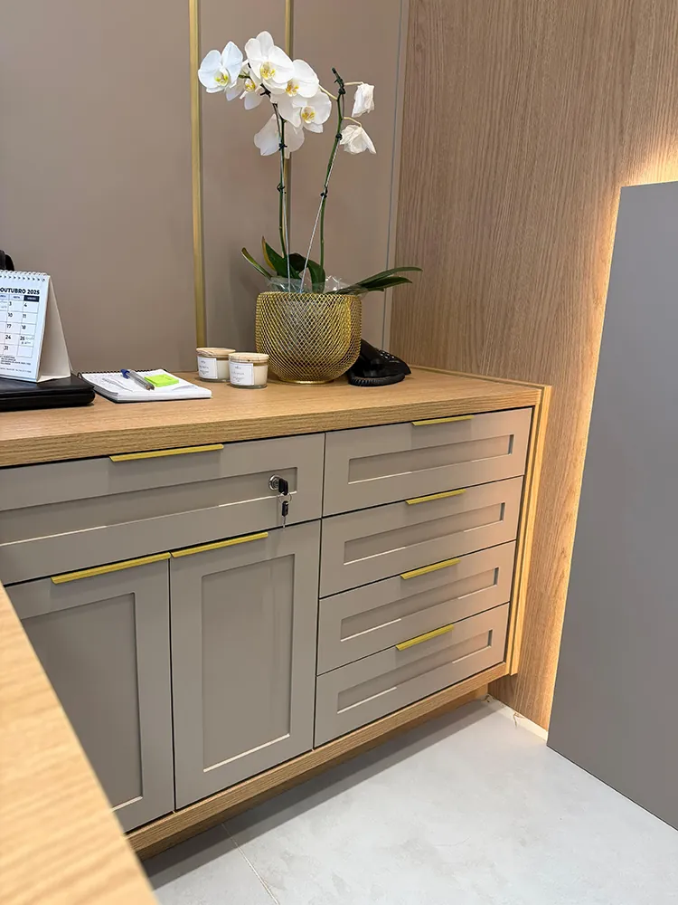 Balcão de recepção com gavetas e puxadores dourados — marcenaria Grupo Adriel
