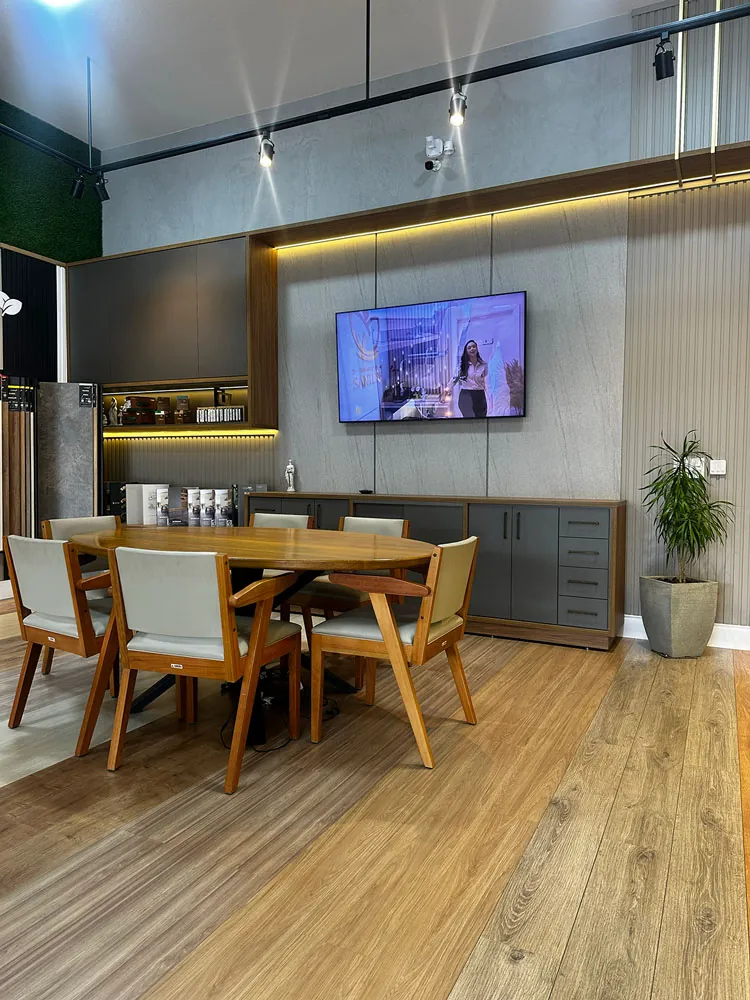 Sala principal do showroom Grupo Adriel — mesa de atendimento e mobiliário